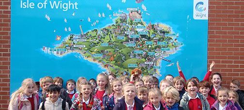 Smiling school children arrive for their Dorset school trip 